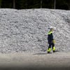 Stena Aluminium employee walking infront of a pile of aluminium