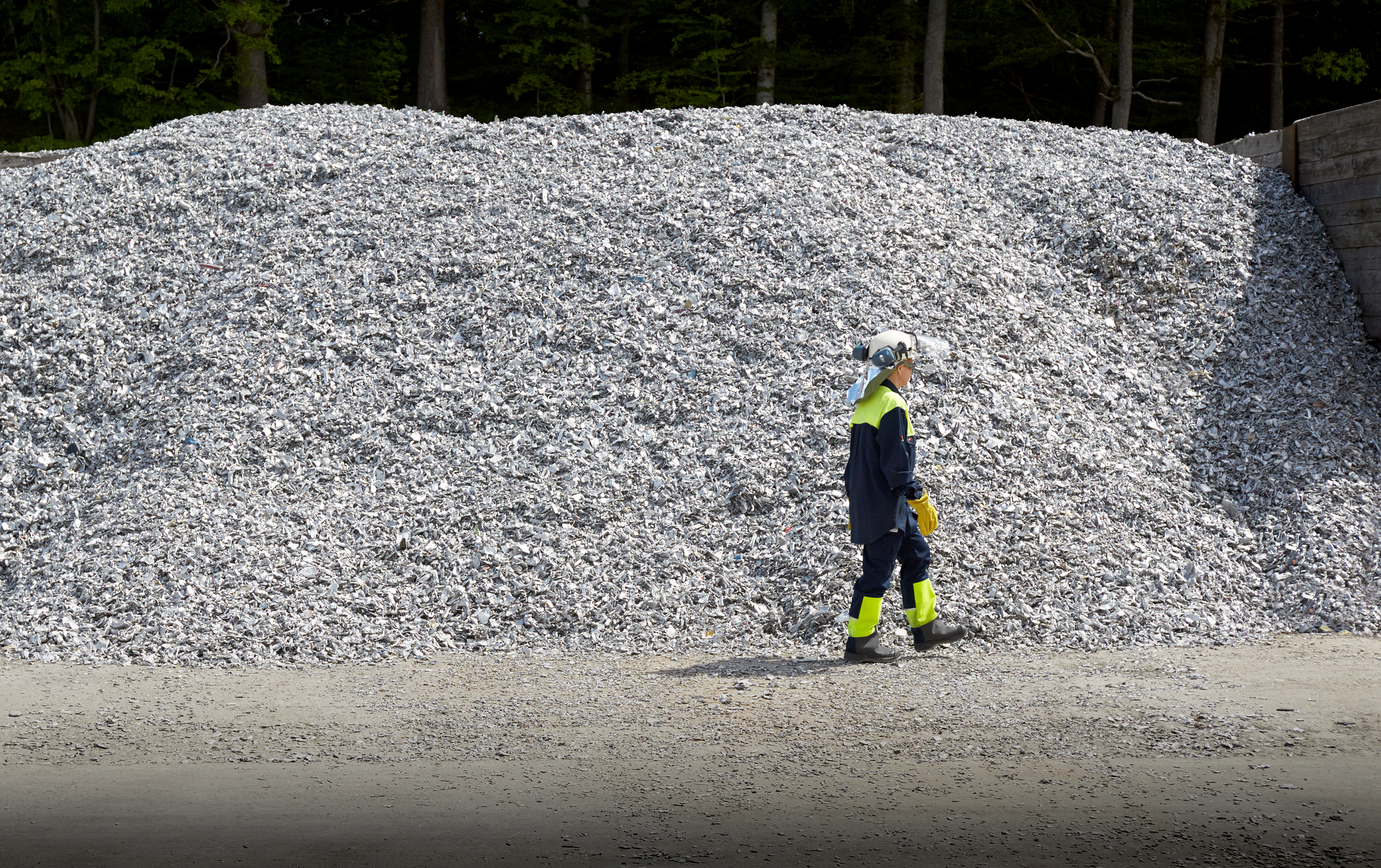 A Stena Aluminium walking in front of a pile of aluminium