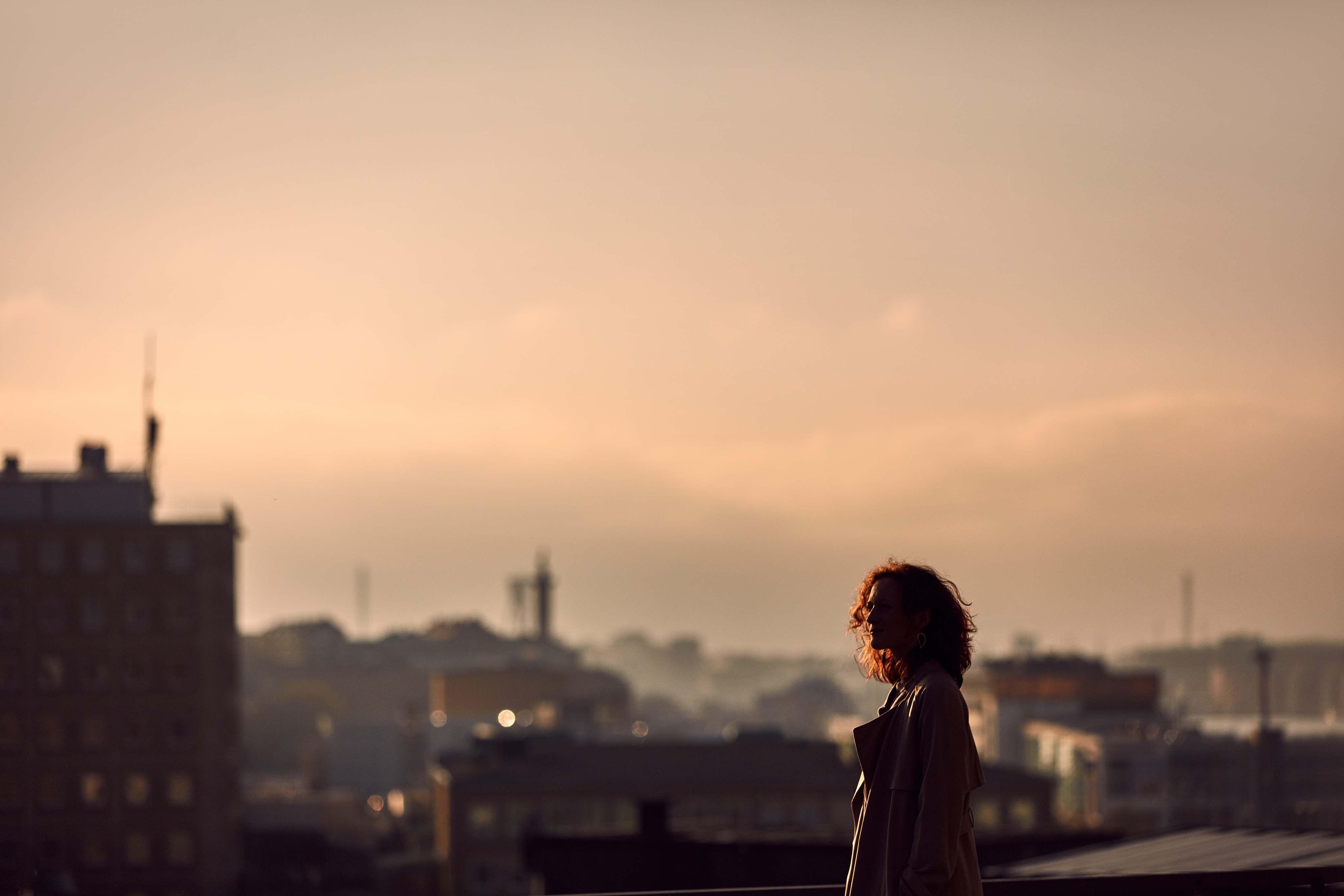 A woman with red hair standing infront of the skyline in Gothenburg, Sweden