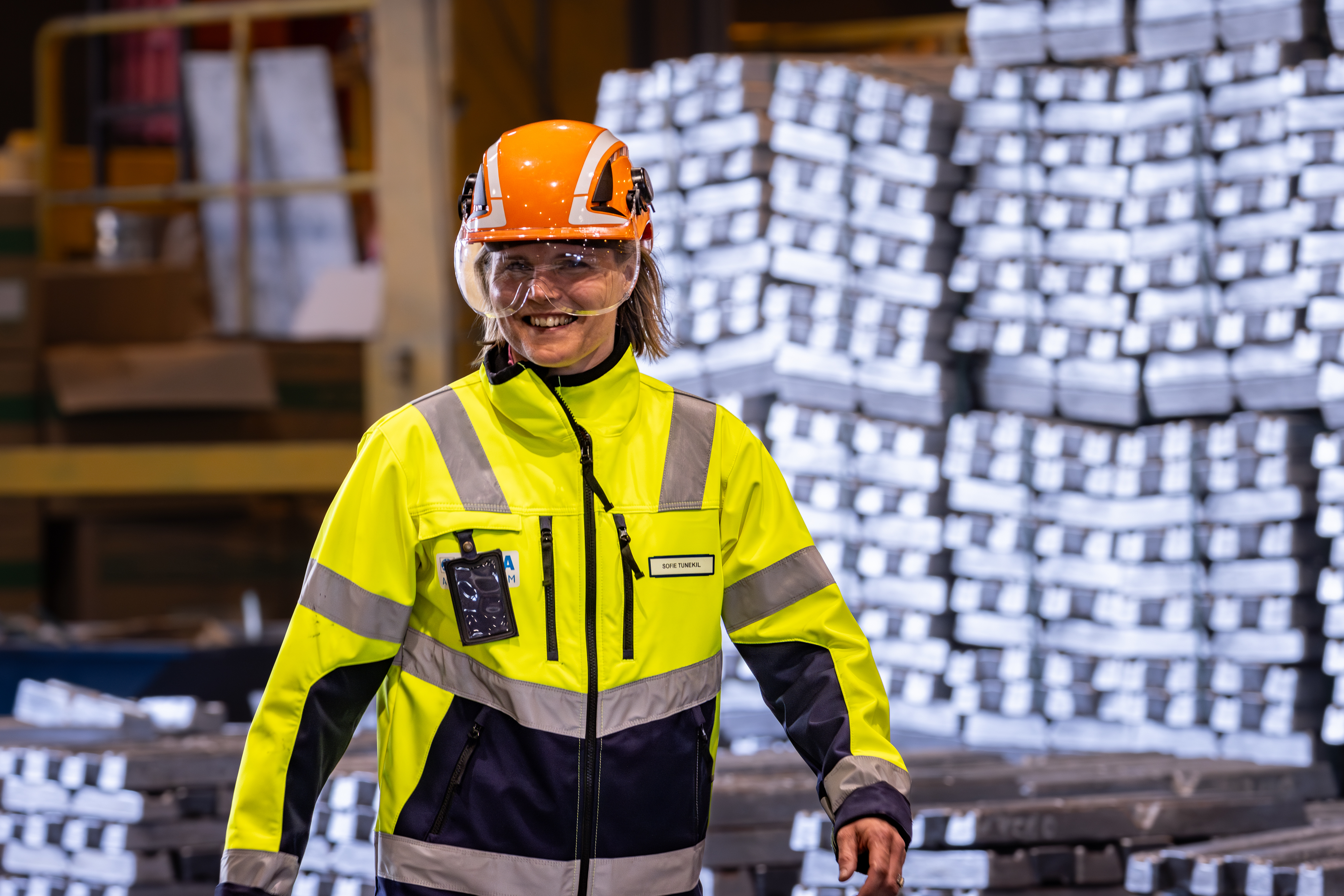 Stena Aluminium-anställd som går igenom produktionsmiljön och ler.