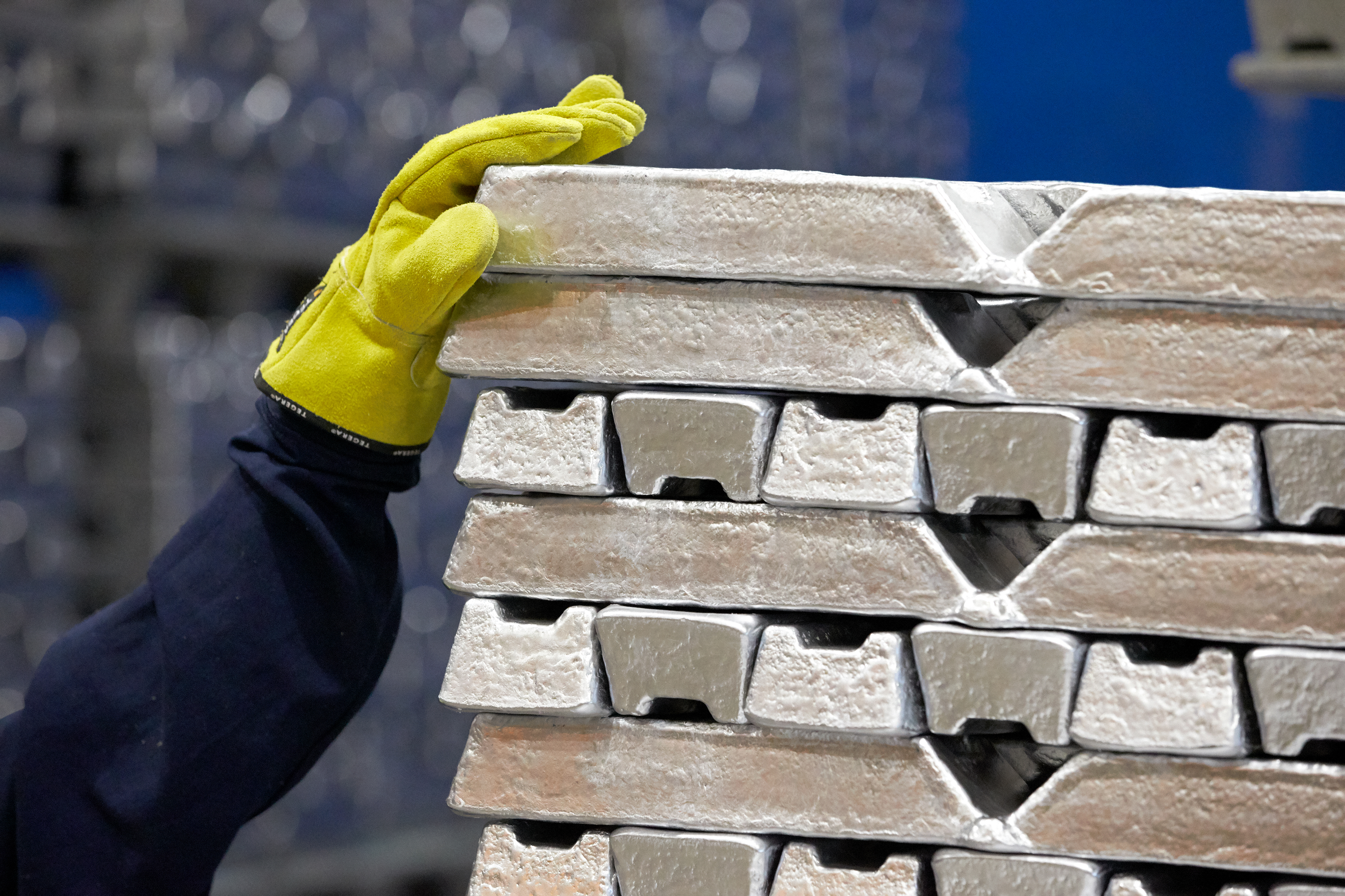 Ein Mitarbeiter von Stena Aluminium platziert von Hand auf Aluminiumbarren, die von Stena Aluminium hergestellt wurden